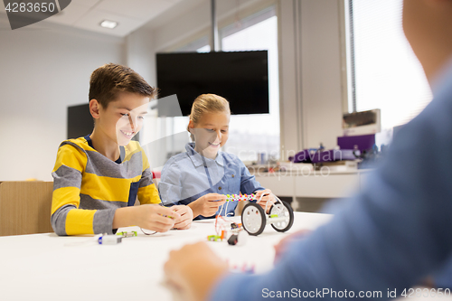 Image of happy children building robots at robotics school