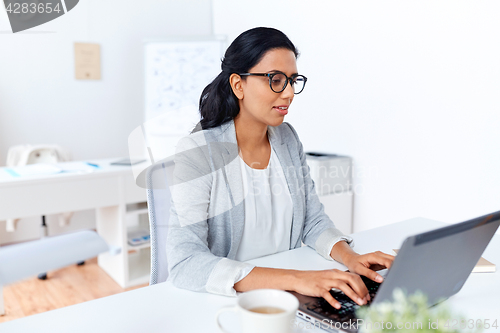 Image of businesswoman with laptop working at office