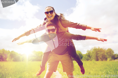 Image of happy couple with backpacks having fun outdoors