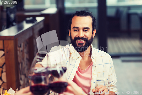Image of happy man clinking glass of wine at restaurant