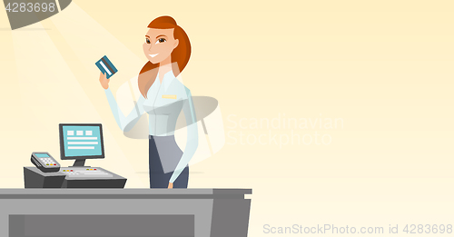 Image of Caucasian cashier holding a credit card.