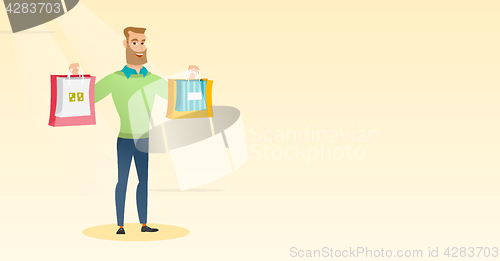 Image of Young caucasian man holding shopping bags.