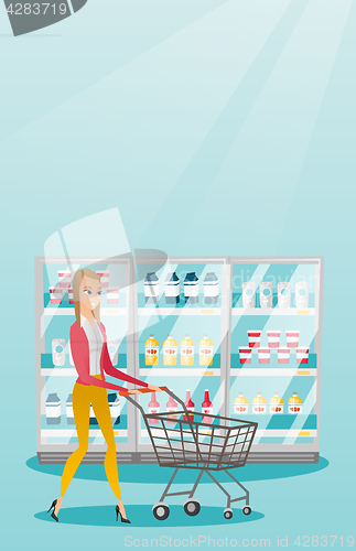 Image of Young caucasian woman with supermarket trolley.