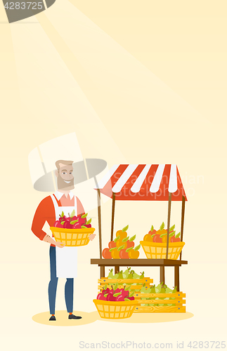 Image of Greengrocer holding box full of apples.