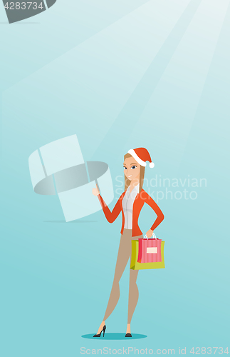 Image of Woman in santa hat shopping for christmas gifts.