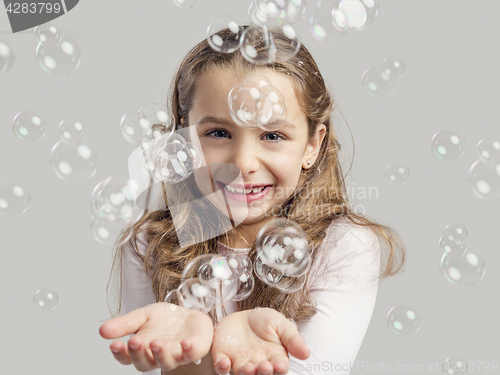 Image of Girl playing with soap bubbles