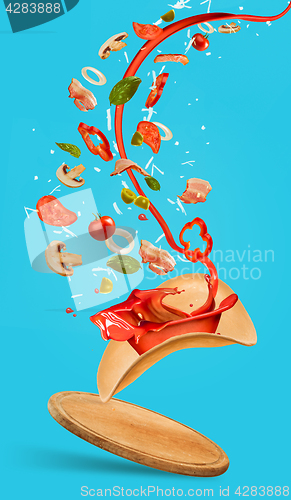 Image of Tasty pizza and falling ingredients on blue background