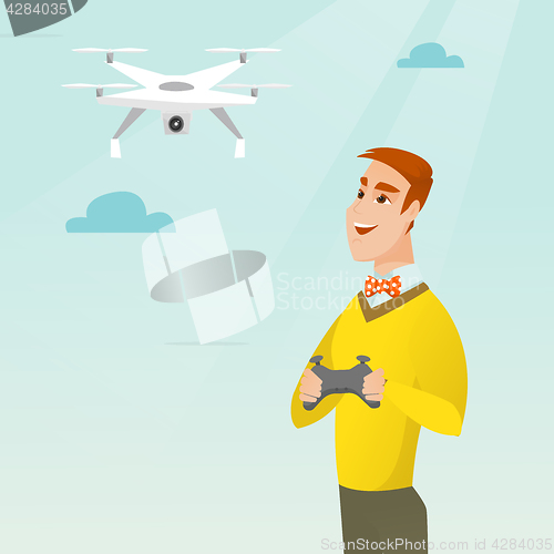 Image of Young caucasian man flying drone.