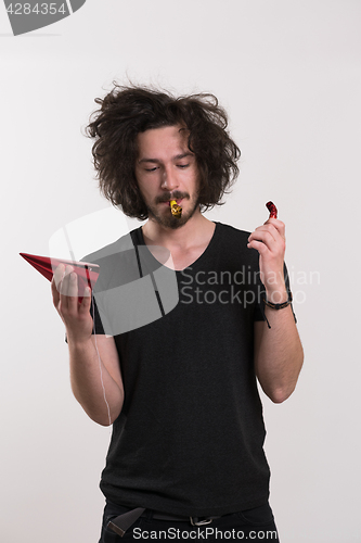 Image of Portrait of a man in party hat blowing in whistle