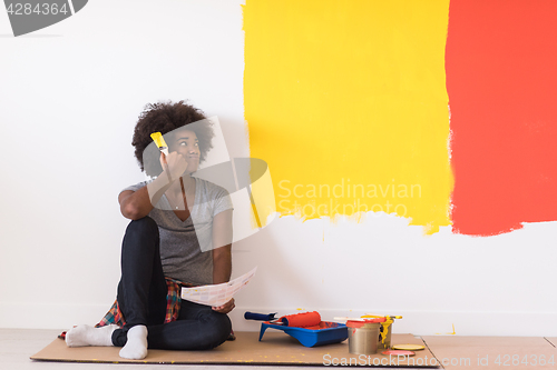 Image of back female painter sitting on floor