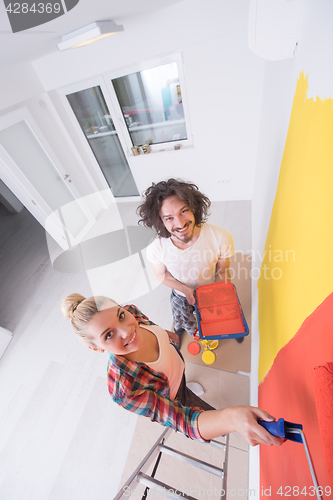 Image of couple painting interior wall