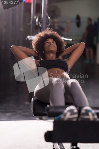 Image of black woman doing sit ups at the gym