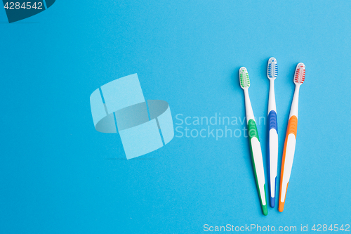 Image of Three toothbrushes on blue background