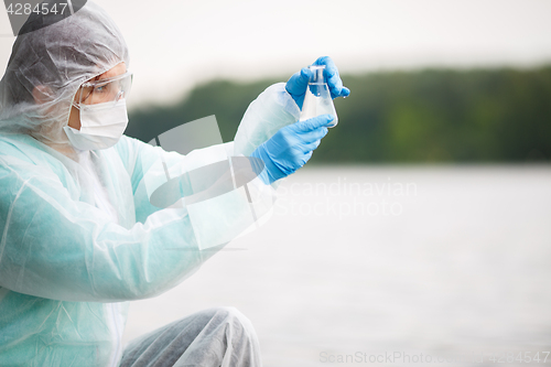 Image of Chemist looks at water flask