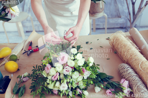 Image of Woman makes composition of flowers