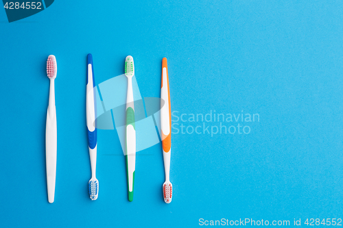 Image of Multi-colored toothbrushes on blue background