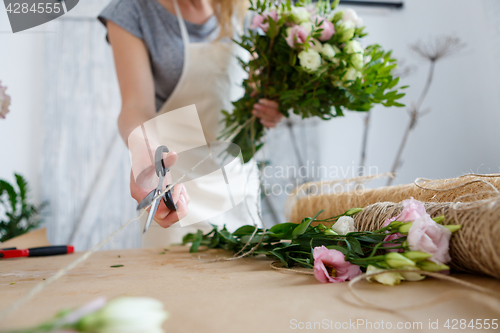 Image of Girl florist makes beautiful bouquet