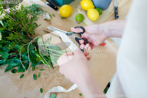 Image of Florist cuts ribbon for bouquet