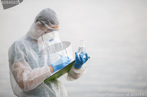 Image of Ecologist writes in folder ,river