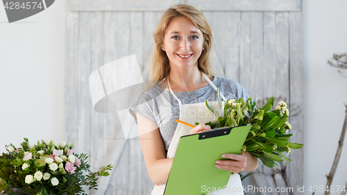 Image of Florist woman writes down orders