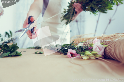 Image of Woman florist makes beautiful bouquet