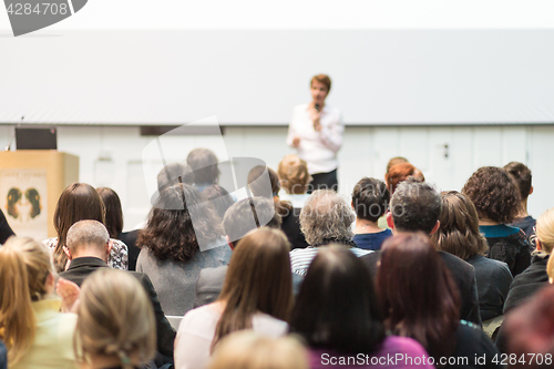 Image of Woman giving presentation in lecture hall at university.