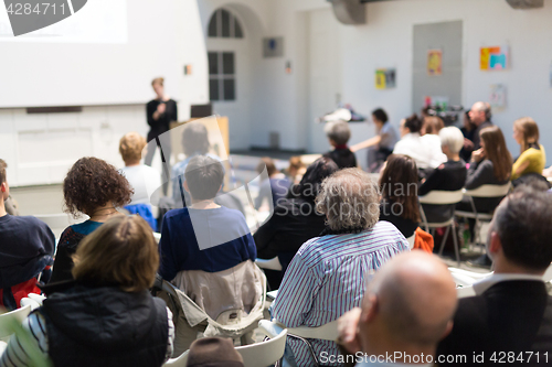 Image of Woman giving presentation in lecture hall at university.