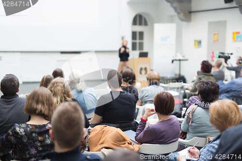 Image of Woman giving presentation in lecture hall at university.