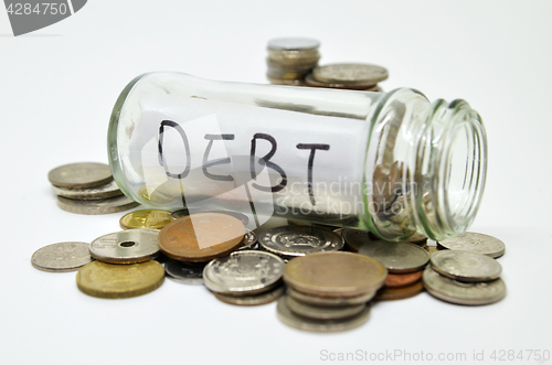 Image of Debt lable in a glass jar with coins spilling out