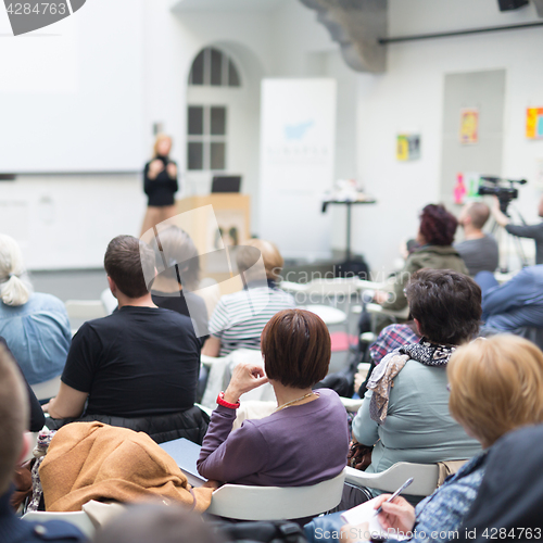 Image of Woman giving presentation in lecture hall at university.