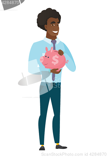 Image of Caucasian business man holding a piggy bank.