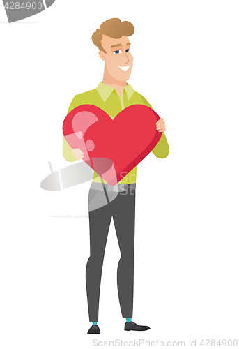 Image of Caucasian business man holding a big red heart.