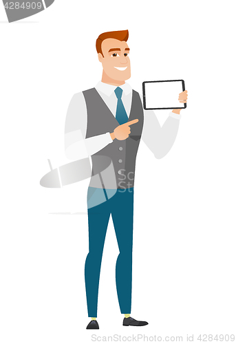 Image of Smiling businessman holding tablet computer.