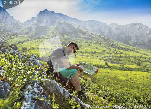 Image of The Hiker with a Map in Misty Mountains