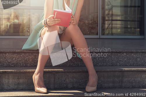 Image of woman with beauty leg holding a book