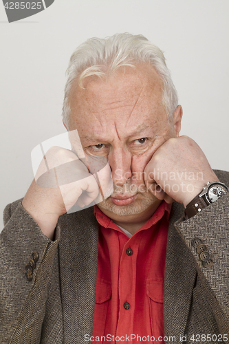 Image of Elderly person puts his face in his hands