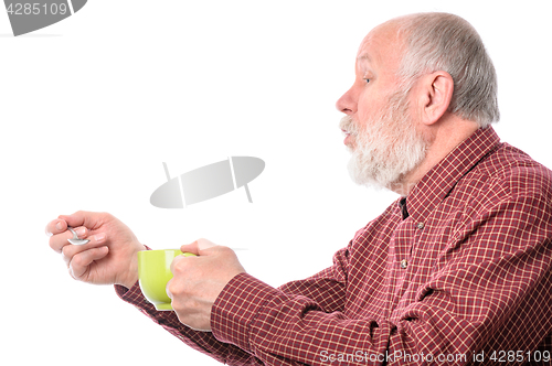 Image of Cheerfull senior man with green cup and teaspoon, isolated on white