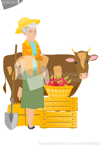 Image of Senior farmer standing with crossed arms near cow.