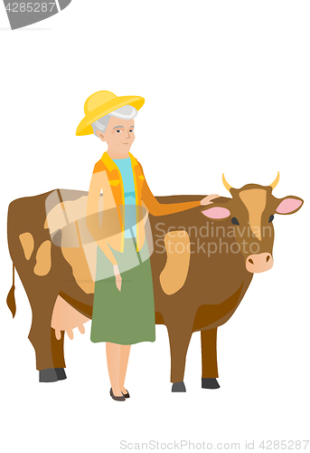 Image of Senior farmer standing with crossed arms near cow.