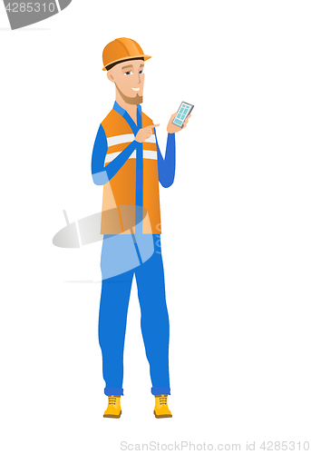 Image of Young caucasian builder holding a mobile phone.