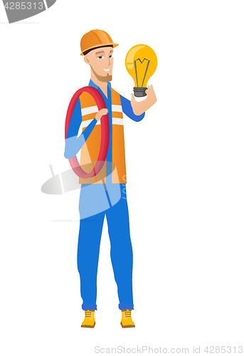 Image of Young caucasian electrician holding lightbulb.