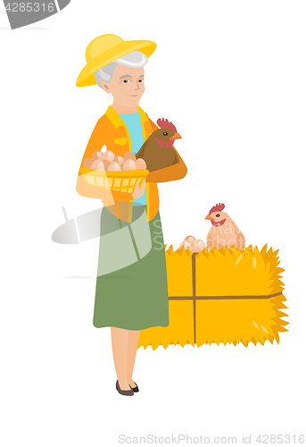 Image of Senior farmer holding chicken and basket of eggs.