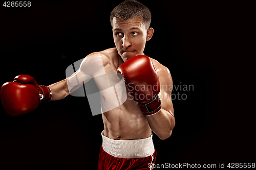 Image of Male boxer boxing with dramatic edgy lighting in a dark studio