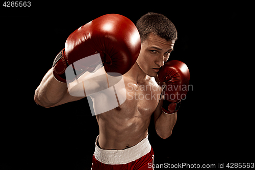 Image of Male boxer boxing with dramatic edgy lighting in a dark studio