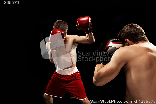 Image of Two professional boxer boxing on black background,