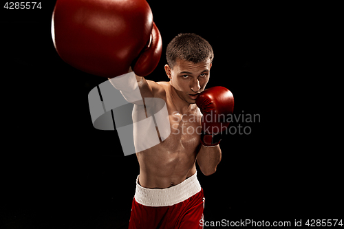 Image of Male boxer boxing with dramatic edgy lighting in a dark studio