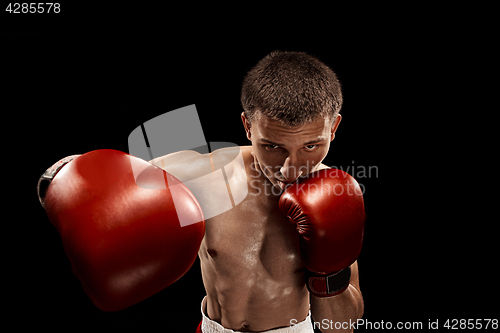 Image of Male boxer boxing with dramatic edgy lighting in a dark studio