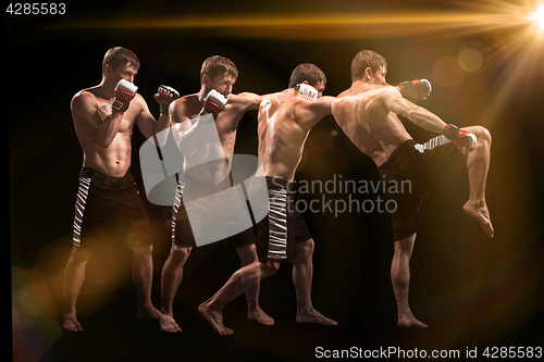 Image of Male boxer boxing in punching bag with dramatic edgy lighting in a dark studio