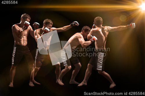 Image of Male boxer boxing in punching bag with dramatic edgy lighting in a dark studio