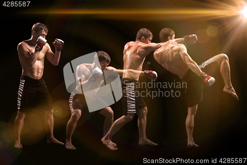 Image of Male boxer boxing in punching bag with dramatic edgy lighting in a dark studio